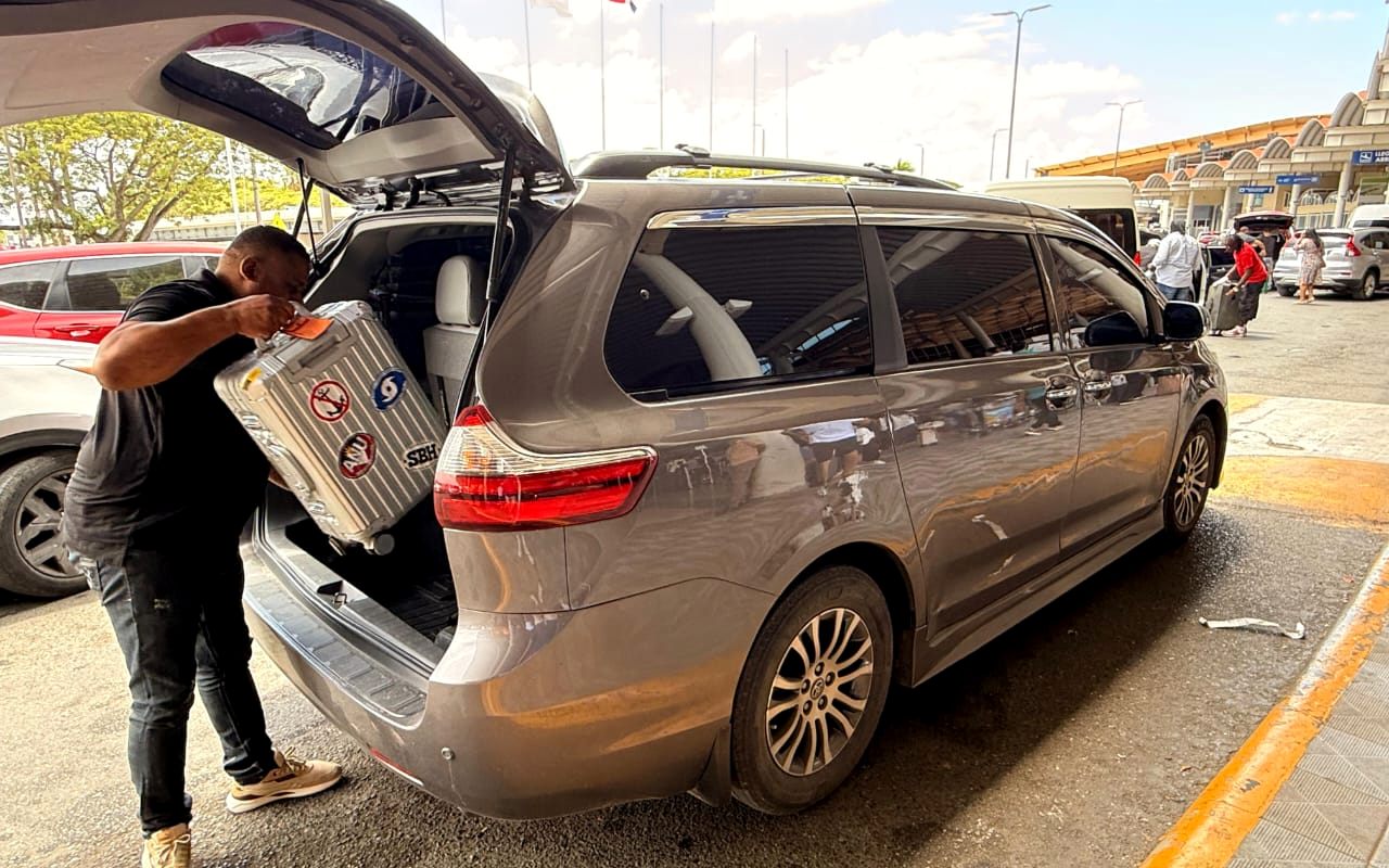 Winton loading a guest’s suitcase into the Toyota minivan at the airport